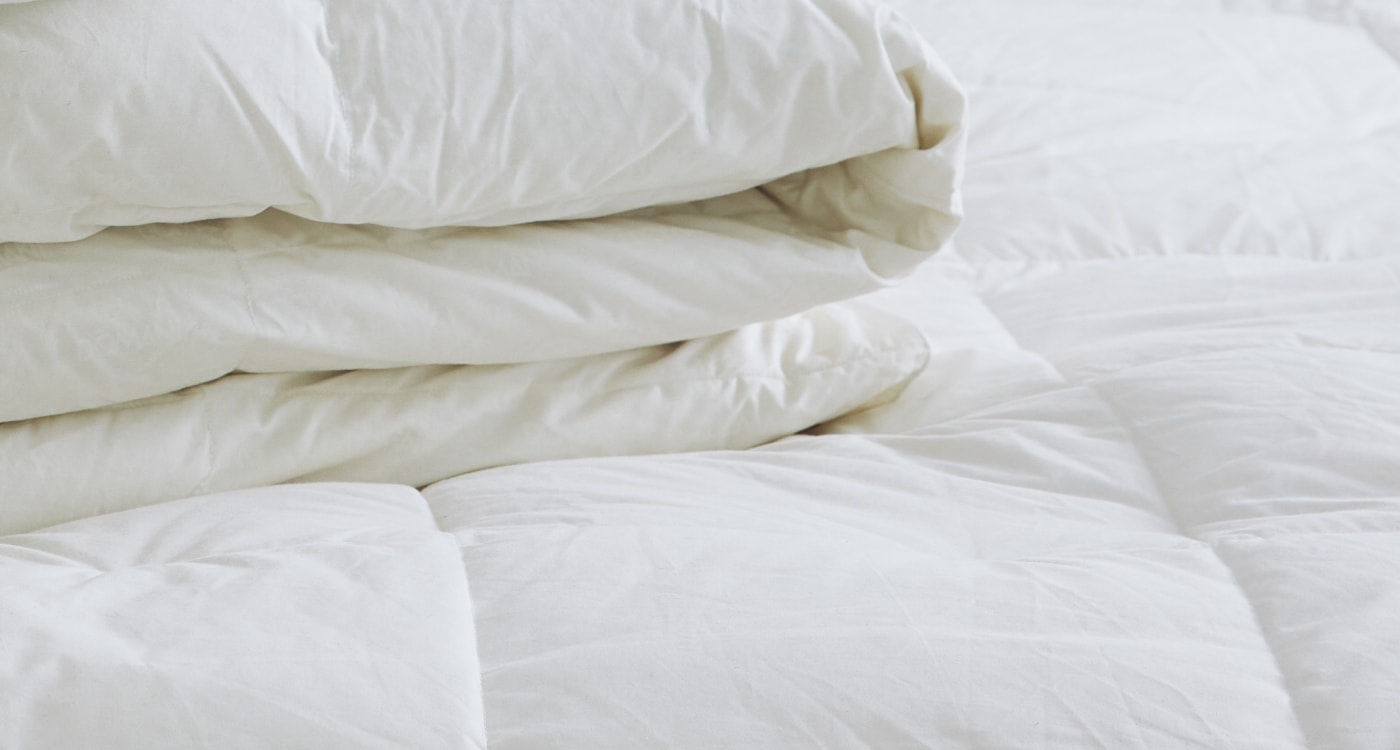 A duck feather and down duvet inner displayed on a bed for the Manchester Duvet Inner Buying Guide