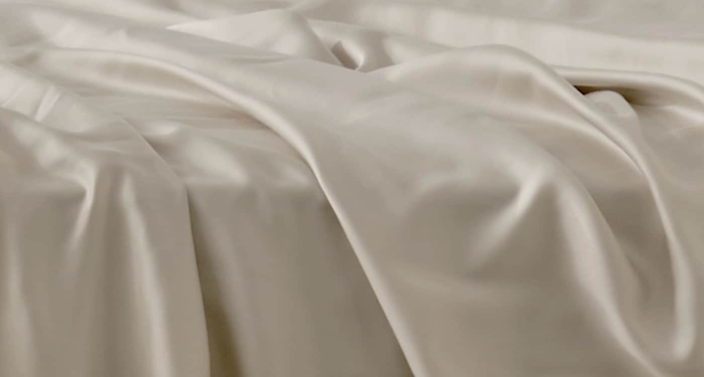 A Tencel sheet set displayed on a bed for the Manchester Sheets Buying Guide