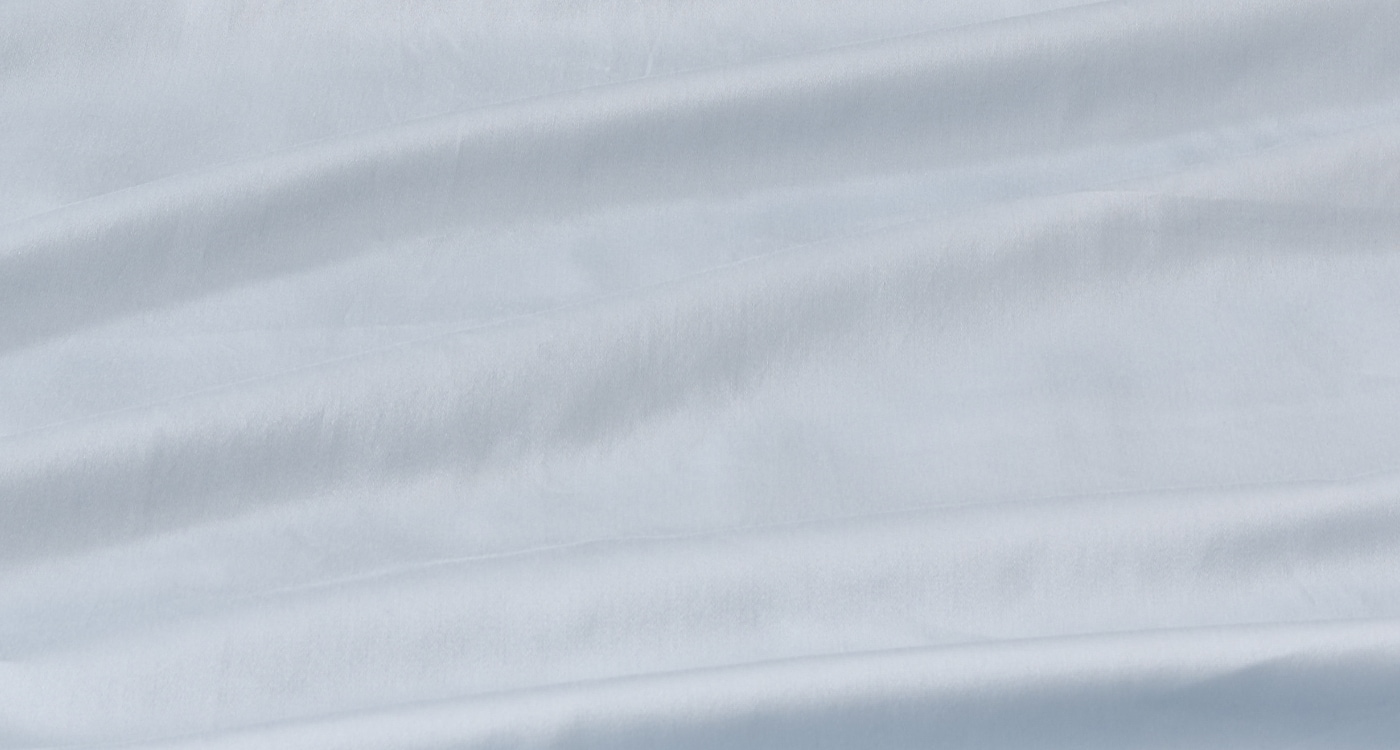 A sateen cotton sheet set displayed on a bed for the Manchester Sheets Buying Guide