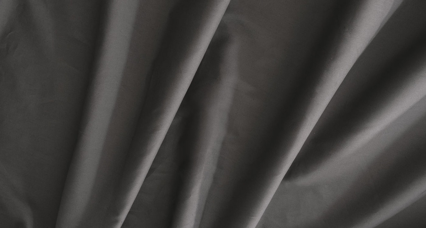 A percale cotton sheet set displayed on a bed for the Manchester Sheets Buying Guide