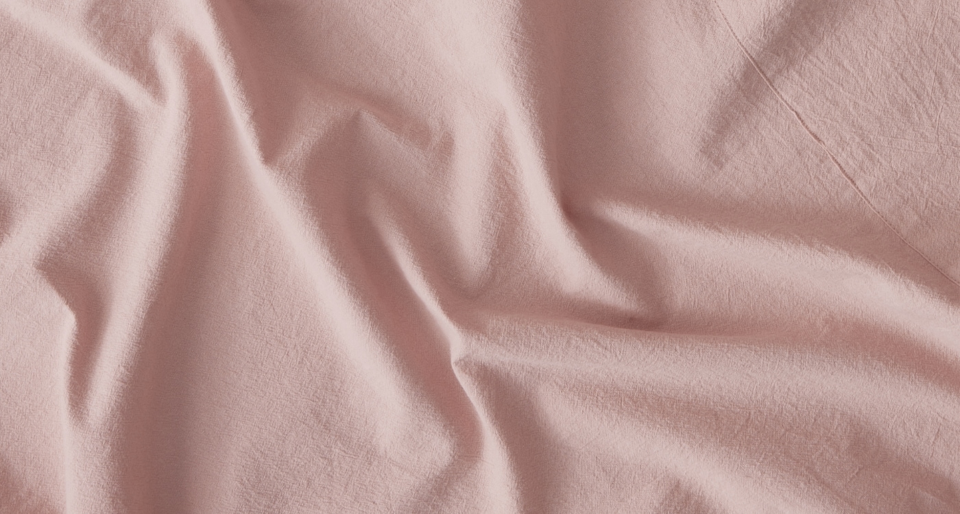 A stone washed cotton sheet set displayed on a bed for the Manchester Sheets Buying Guide