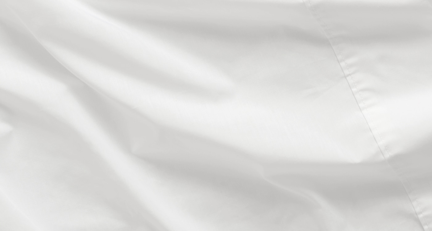 A cotton rich sheet set displayed on a bed for the Manchester Sheets Buying Guide