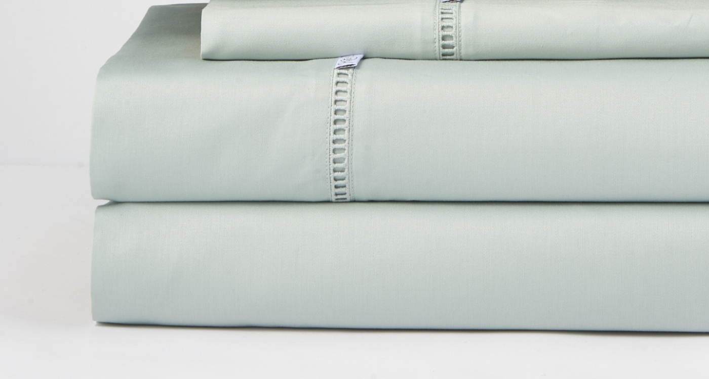 A set of deeper fitted and flat sheets displayed on a bed for the Manchester Sheets Buying Guide